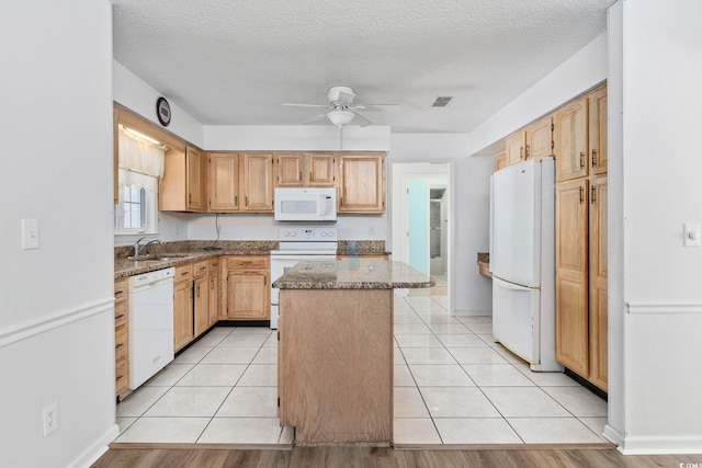 703 Gleneagles Dr, Myrtle Beach, SC 29588 - kitchen featuring light stone countertops, a center island, light tile patterned floors, and white appliances