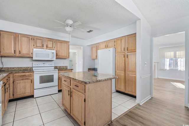 703 Gleneagles Dr, Myrtle Beach, SC 29588 - kitchen with a textured ceiling, white appliances, ceiling fan, a kitchen island, and light tile patterned flooring
