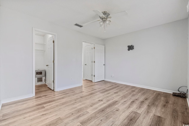 703 Gleneagles Dr, Myrtle Beach, SC 29588 - unfurnished bedroom with a walk in closet, light wood-type flooring, a closet, and ceiling fan
