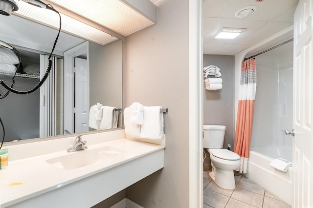 full bathroom with sink, shower / bath combo, tile patterned flooring, a drop ceiling, and toilet