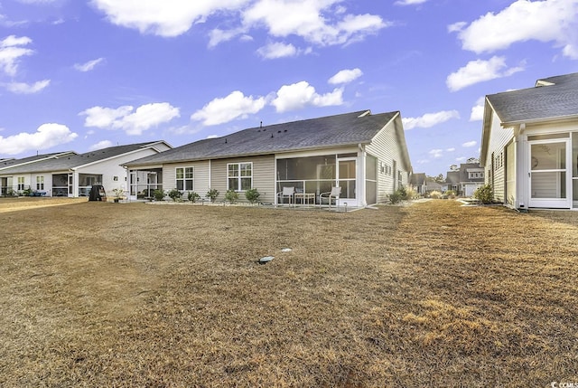 rear view of house featuring a sunroom