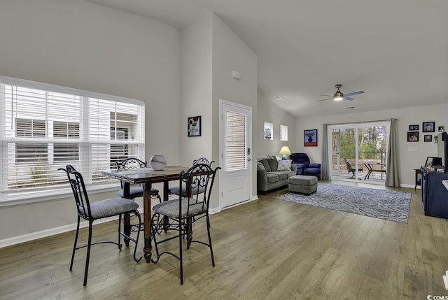 dining space featuring ceiling fan, vaulted ceiling, and light hardwood / wood-style flooring