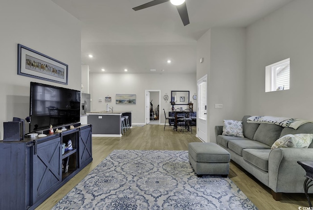 living room with light hardwood / wood-style floors, ceiling fan, a healthy amount of sunlight, and sink