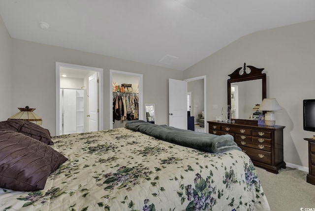 carpeted bedroom featuring a spacious closet, a closet, and vaulted ceiling