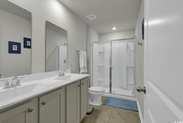 bathroom featuring tile patterned flooring, vanity, toilet, and a shower with shower door