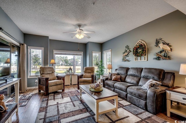 living room with hardwood / wood-style floors, a textured ceiling, and ceiling fan