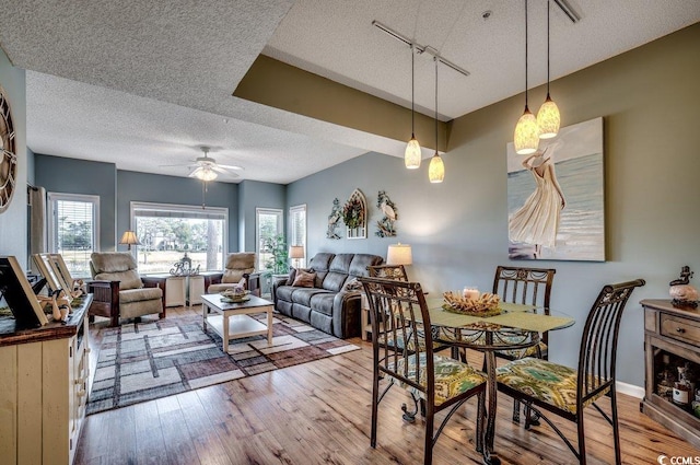 dining room featuring a textured ceiling, light hardwood / wood-style floors, and ceiling fan