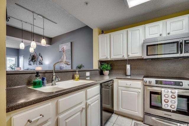 kitchen featuring sink, dishwasher, track lighting, white cabinets, and range