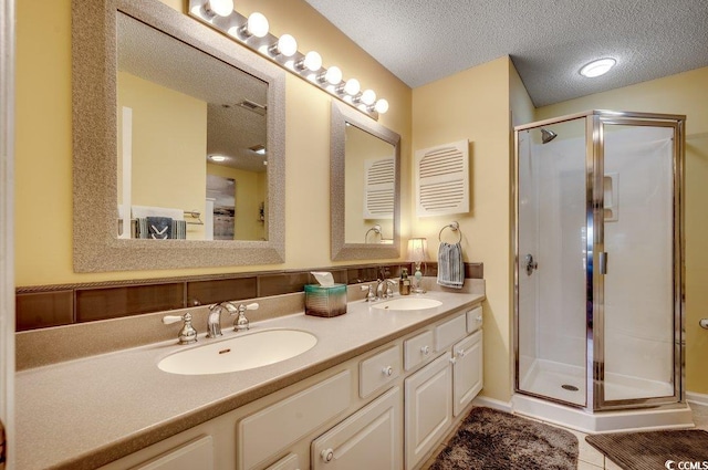 bathroom featuring vanity, a textured ceiling, tile patterned floors, and walk in shower