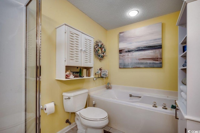 bathroom with a washtub, toilet, and a textured ceiling