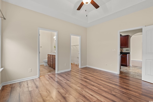 817 Payne Ct, Conway, SC 29526 - unfurnished bedroom featuring baseboards, light wood-type flooring, a raised ceiling, a spacious closet, and ensuite bath