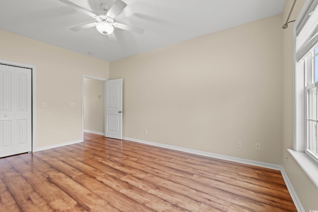 unfurnished bedroom featuring light wood finished floors, a closet, a ceiling fan, and baseboards