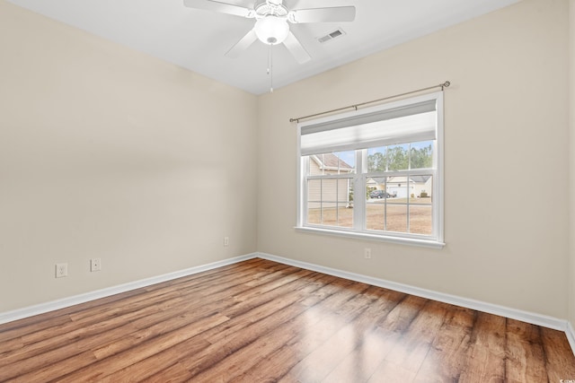 empty room featuring light wood-type flooring, baseboards, visible vents, and ceiling fan