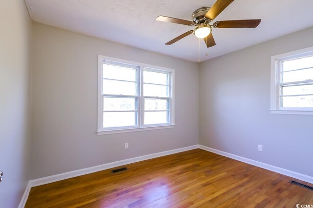 empty room featuring hardwood / wood-style floors and ceiling fan