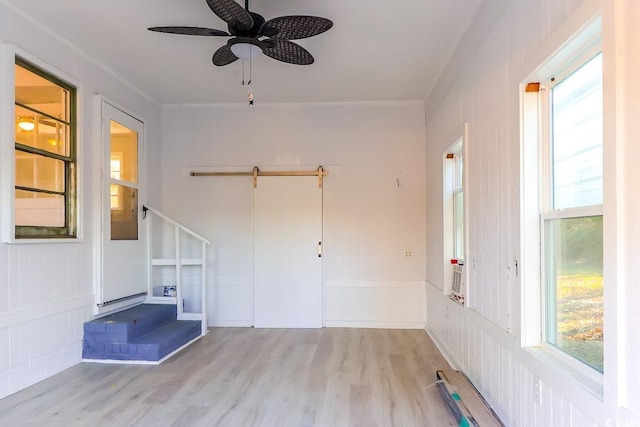 interior space with ceiling fan, crown molding, and light wood-type flooring