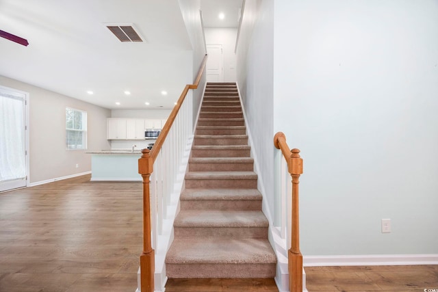 stairway with hardwood / wood-style floors