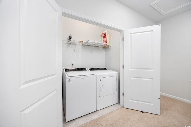 laundry area with washer and clothes dryer and light tile patterned flooring