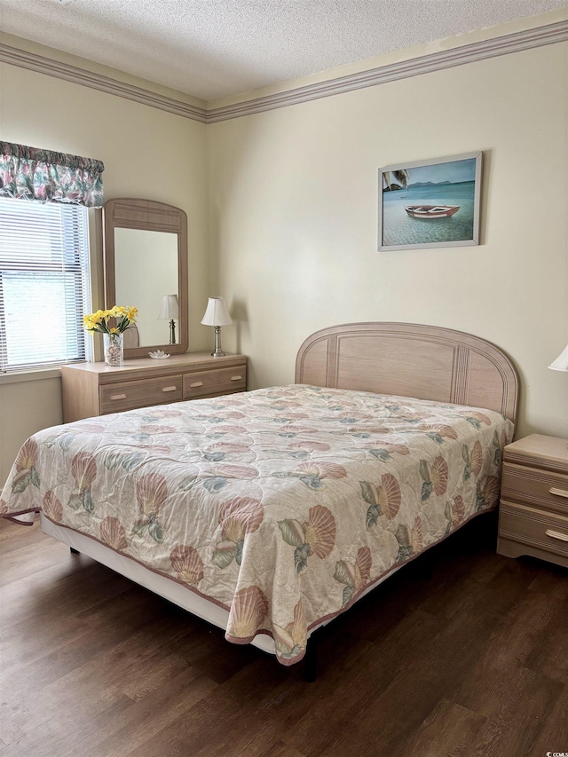 bedroom featuring crown molding, a textured ceiling, and dark wood-type flooring