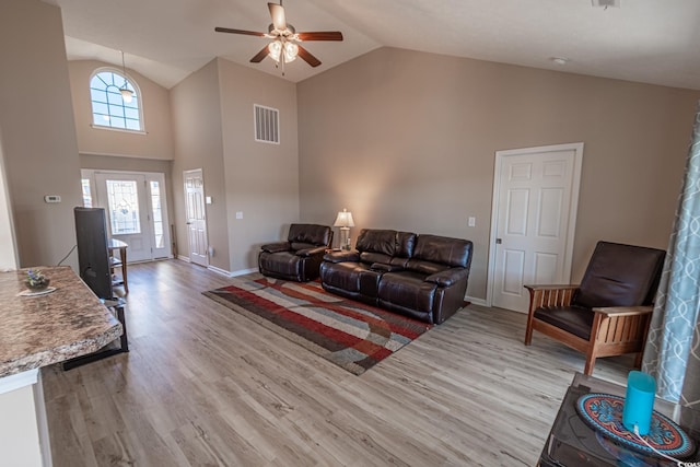 living room featuring ceiling fan, vaulted ceiling, and light wood-type flooring