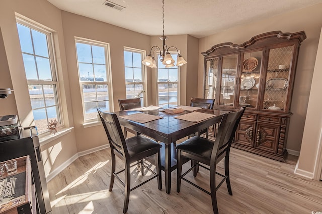 dining area featuring light hardwood / wood-style floors and a notable chandelier