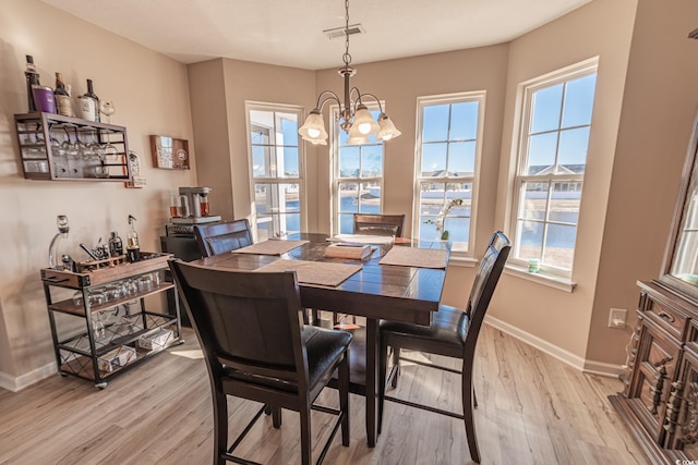 dining space featuring light hardwood / wood-style floors and a chandelier