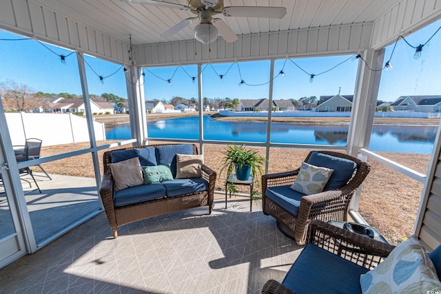 sunroom featuring a water view and ceiling fan