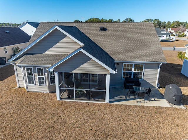 back of house featuring a sunroom, a yard, and a patio