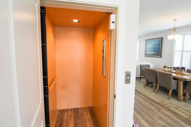 room details with elevator and hardwood / wood-style flooring