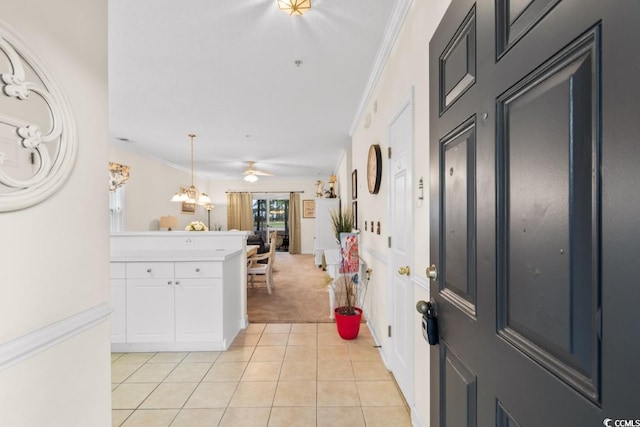 carpeted entryway with ceiling fan and ornamental molding