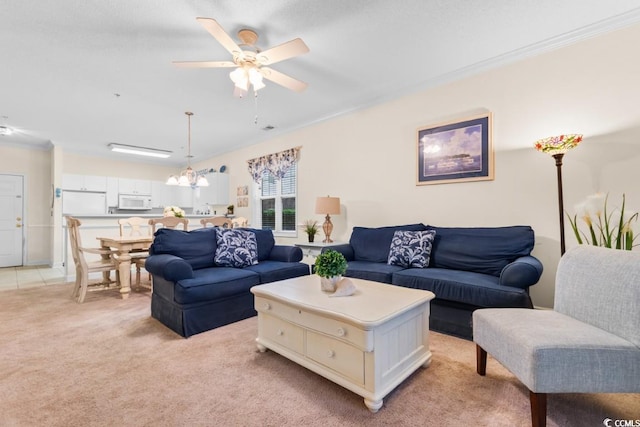 carpeted living room featuring ceiling fan with notable chandelier and crown molding