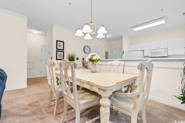 carpeted dining area featuring crown molding and an inviting chandelier