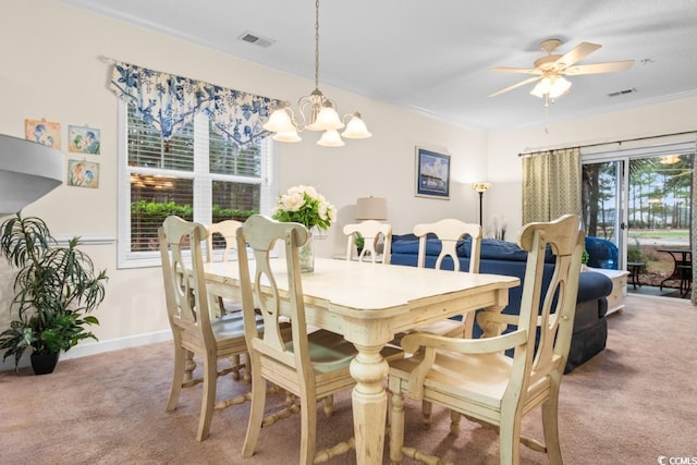 dining area with light carpet, ceiling fan with notable chandelier, and crown molding