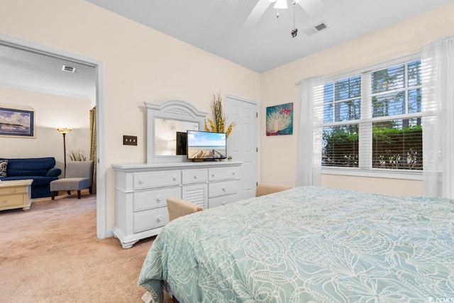 bedroom with ceiling fan and light carpet