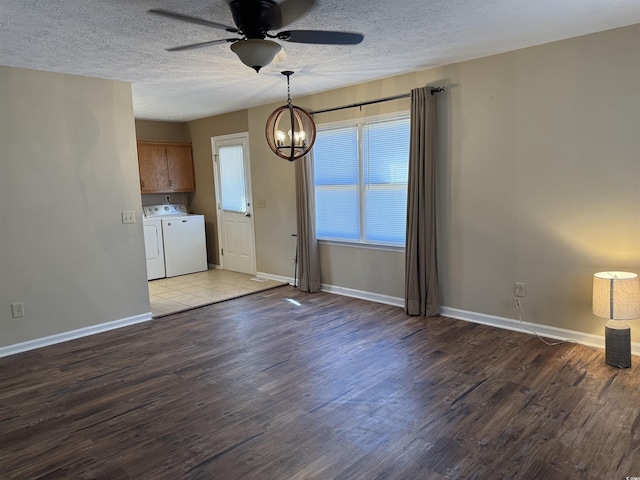 unfurnished dining area featuring washing machine and clothes dryer, dark hardwood / wood-style flooring, a textured ceiling, and ceiling fan with notable chandelier