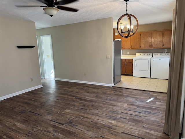 kitchen featuring stainless steel fridge, pendant lighting, light wood-type flooring, and independent washer and dryer