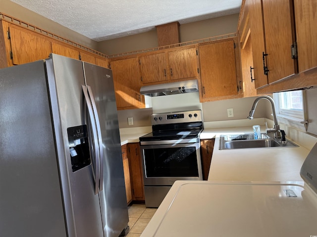 kitchen with sink, a textured ceiling, light tile patterned flooring, stainless steel appliances, and extractor fan