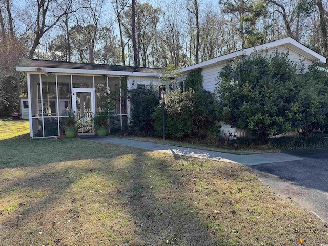 view of front of property featuring a front lawn and a sunroom