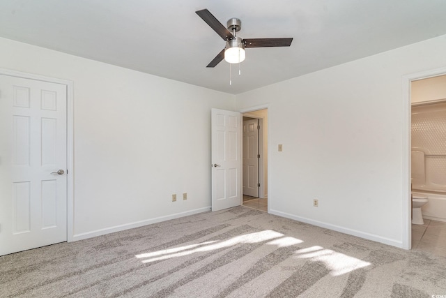 unfurnished bedroom featuring ensuite bathroom, ceiling fan, and light colored carpet