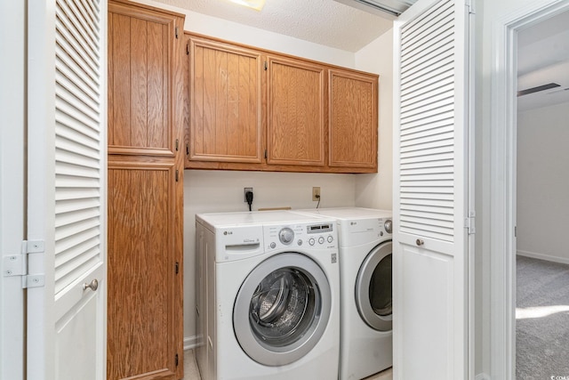 laundry room with light colored carpet, cabinets, a textured ceiling, and independent washer and dryer