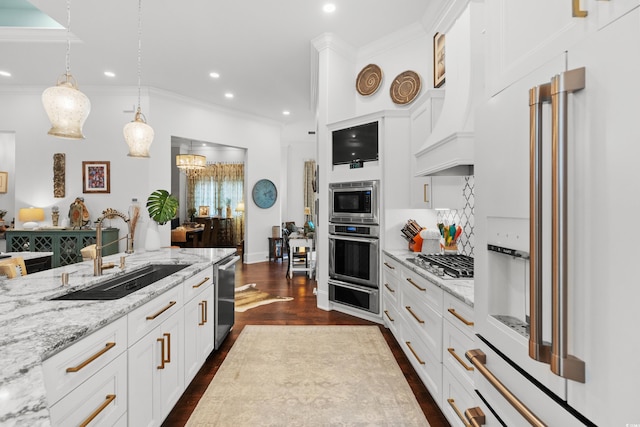 kitchen with white cabinets, stainless steel appliances, light stone countertops, custom range hood, and sink