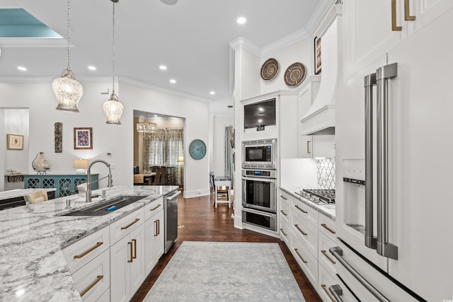 kitchen with sink, appliances with stainless steel finishes, white cabinetry, light stone counters, and decorative light fixtures