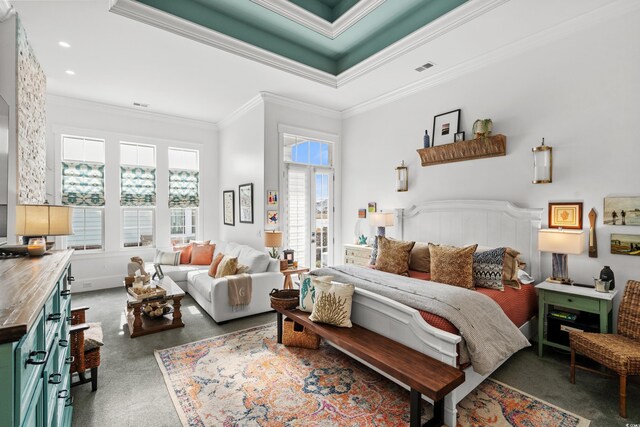 bedroom with crown molding, a raised ceiling, and multiple windows