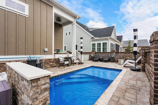 view of pool with exterior bar and a patio area