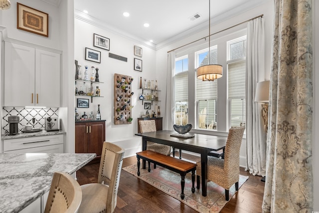 dining room with crown molding and dark hardwood / wood-style floors