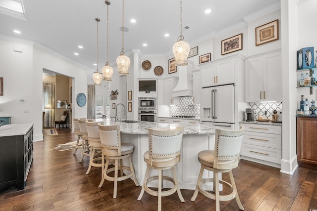 kitchen featuring a large island, a breakfast bar area, white cabinetry, stainless steel appliances, and decorative light fixtures