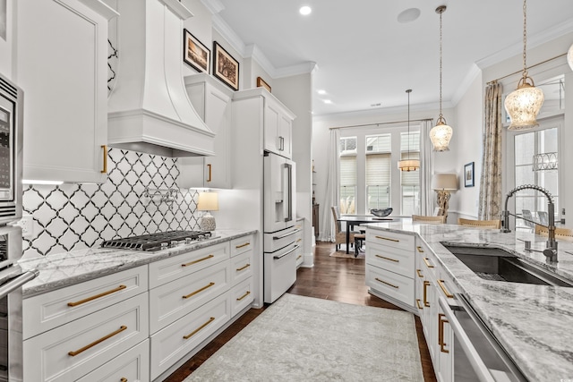 kitchen featuring premium range hood, white cabinetry, and sink