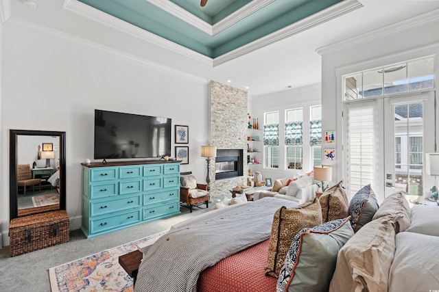 bedroom featuring a fireplace, access to outside, a raised ceiling, crown molding, and light carpet