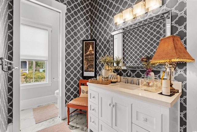 bar with light stone counters, sink, and white cabinets