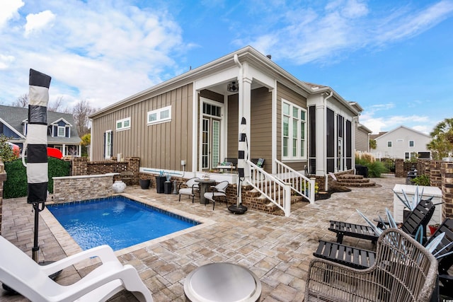 view of swimming pool with a patio area and a sunroom