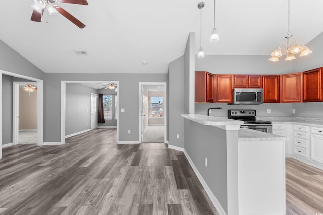 kitchen featuring lofted ceiling, kitchen peninsula, light hardwood / wood-style flooring, white cabinetry, and stainless steel appliances